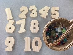 the numbers are made out of wood and have buttons in them next to a wicker basket