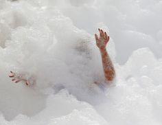 a person laying in the snow with their feet up and arms out to touch it