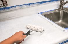 a person using a brush to clean a kitchen counter