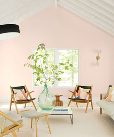 a living room filled with furniture and a plant in a vase on top of a table