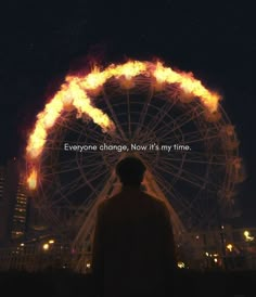 a man standing in front of a ferris wheel with the words everyone change now it's my time