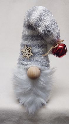 a stuffed animal wearing a hat with a bell on it's head and a snowflake around its neck