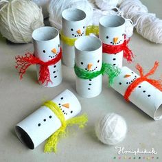 snowman toilet paper roll craft with yarn and balls of yarn in the foreground