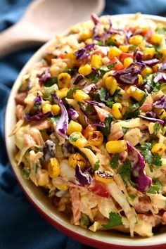 a red bowl filled with corn salad and garnished with cilantro