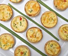 several mini quiches on a plate with green asparagus