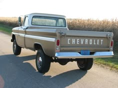 an old chevrolet truck is parked on the side of the road