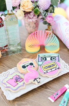 decorated cookies are sitting on a table next to flowers and other decorative items in front of them