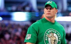 a man wearing a green shirt and hat in front of a crowd at a sporting event