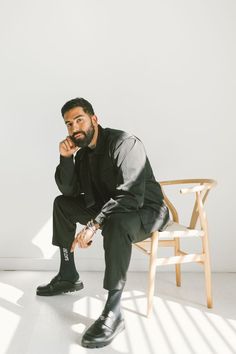 a man sitting in a chair with his hand on his chin