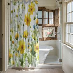 a bathroom with a shower curtain that has yellow flowers on it and a bathtub in the background