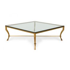 a coffee table with glass top and gold legs