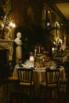 a dining room table is set up with candles and flowers on the centerpieces