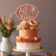 there is a cake that has been decorated with flowers and leaves on the top tier