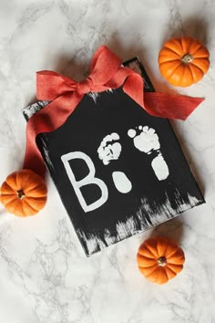 a black sign with the word b is for baby on it next to mini pumpkins