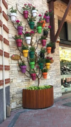 a tree made out of potted plants on the side of a building