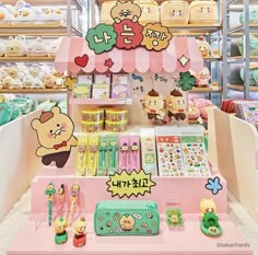 an assortment of items for sale in a store with cartoon characters on the wall behind them