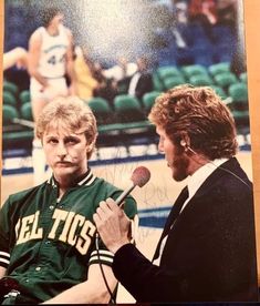 an autographed photo of two men talking to each other in front of a basketball court