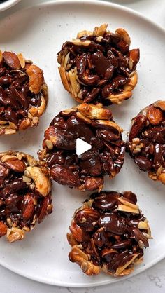 six chocolate covered cookies on a white plate