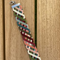 a bracelet made out of seed beads on a wooden surface