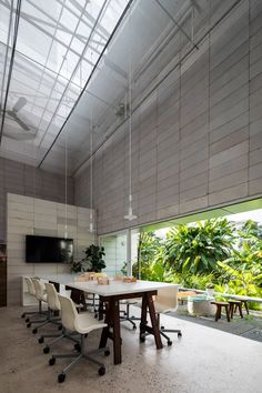 a room with a table, chairs and a television on the wall next to it