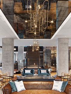 a living room filled with lots of furniture and a chandelier hanging from the ceiling