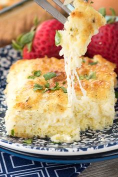 a piece of quiche being lifted from a plate with strawberries