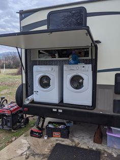 two washers are sitting in the back of a camper with its doors open