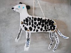 a paper mache cow hanging from a string on a wall with words written all over it