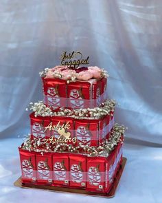 a three tiered cake decorated with coca - cola cans and pink frosting flowers