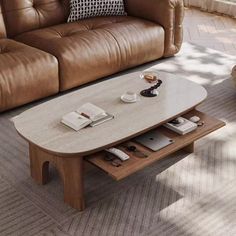 a living room with a couch, coffee table and window in the backround