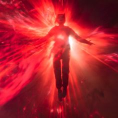 a man standing in the middle of a red and white explosion with his arms outstretched