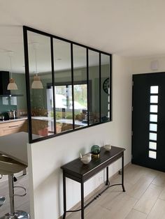 there is a table with two bowls on it in front of the mirror and door