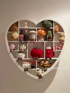 a heart shaped shelf filled with lots of different stuffed animals and toys on it's sides