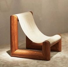 a chair made out of wood and white fabric on the seat is sitting in front of a wall