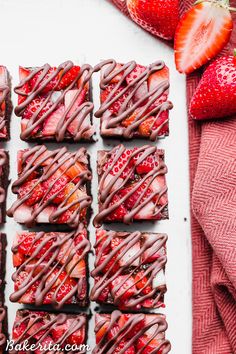 strawberry shortbreads with chocolate drizzled on top and strawberries in the background