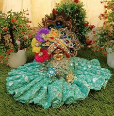 a statue of a peacock sitting on top of a green grass covered ground next to potted plants