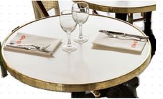 the table is set with two wine glasses and silverware, along with white napkins