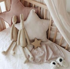 two stuffed animals sitting on top of a bed next to pillows and star shaped pillow