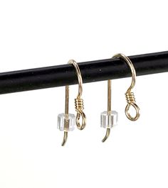 three pairs of earrings hanging from a rail