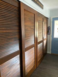 the interior of a home with wooden shutters on the doors and wood flooring