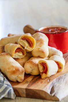 several pastries on a cutting board with dipping sauce