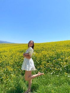 a woman standing in a field with flowers