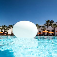 a large white ball floating in the middle of a swimming pool