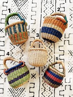 four woven baskets sitting on top of a rug