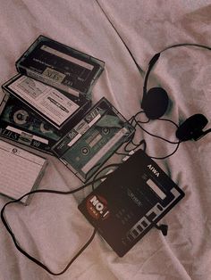 there are several cassettes and headphones on the bed