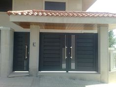 two large black doors in front of a house