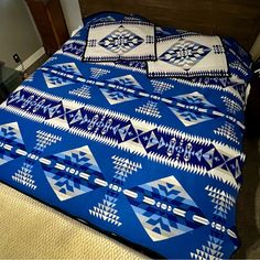 a bed with blue and white bedspread on top of it