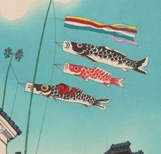 four fish are flying in the sky above some buildings and flags on a sunny day