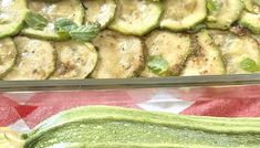 zucchini and other vegetables are sitting on a red table cloth next to each other