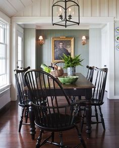 a dining room table with four chairs and a potted plant on top of it